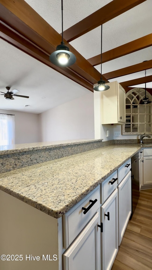 kitchen with light stone countertops, pendant lighting, and dishwasher