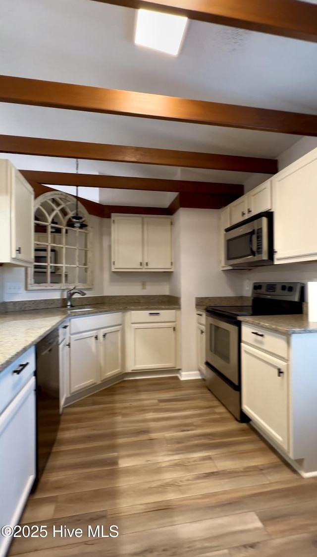 kitchen with white cabinetry, light hardwood / wood-style flooring, and stainless steel appliances