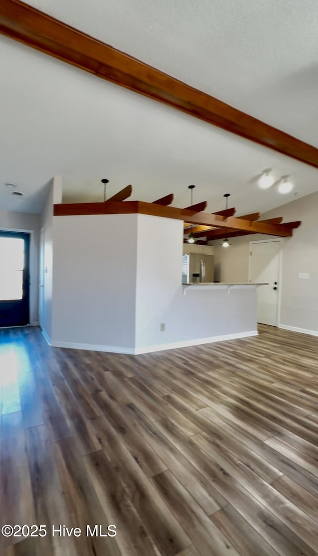 unfurnished living room featuring beamed ceiling and wood-type flooring