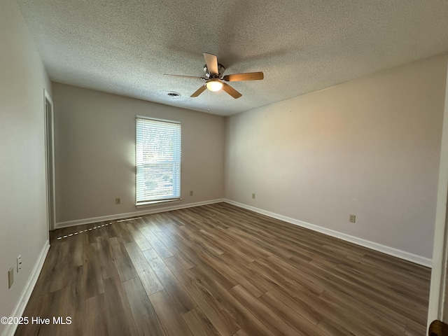 empty room featuring a textured ceiling, ceiling fan, and dark wood-type flooring