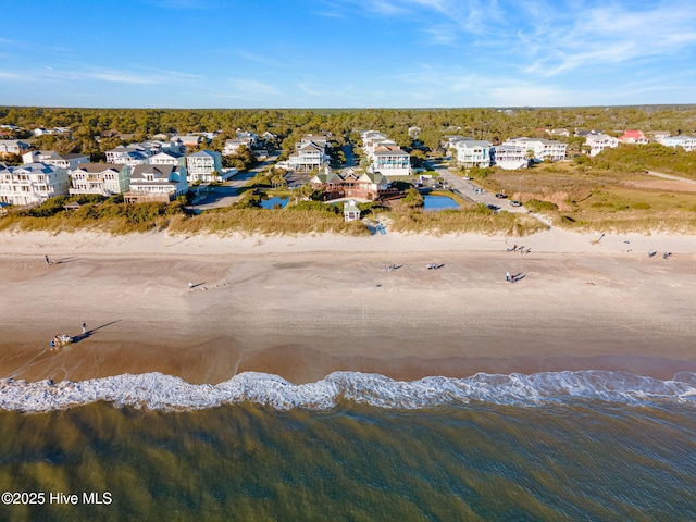drone / aerial view with a water view, a beach view, and a residential view