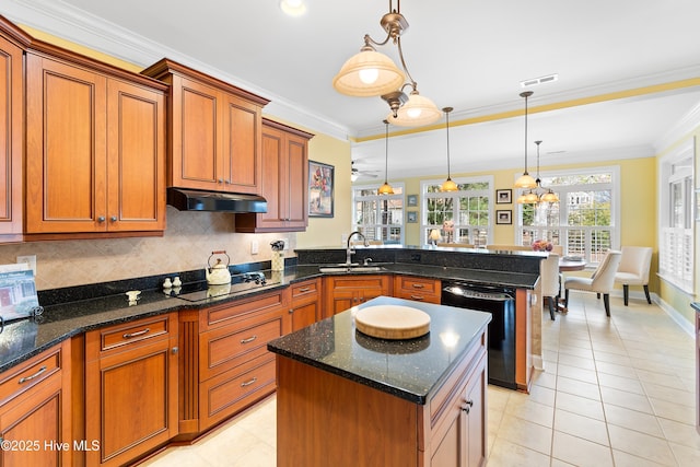 kitchen featuring brown cabinetry, visible vents, a sink, black appliances, and a peninsula