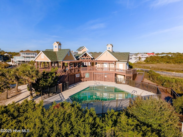 pool featuring stairs, fence, and a deck