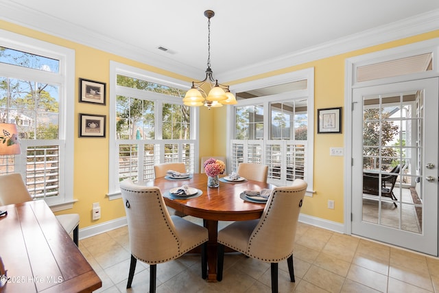 tiled dining room featuring crown molding, plenty of natural light, and an inviting chandelier