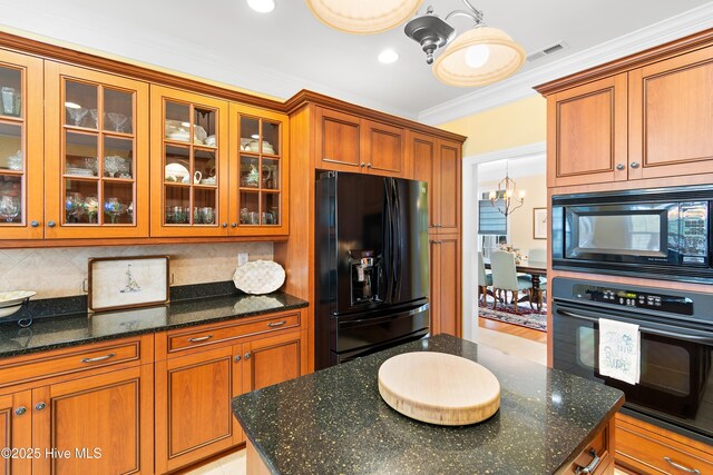 kitchen with tasteful backsplash, dark stone counters, crown molding, and black appliances