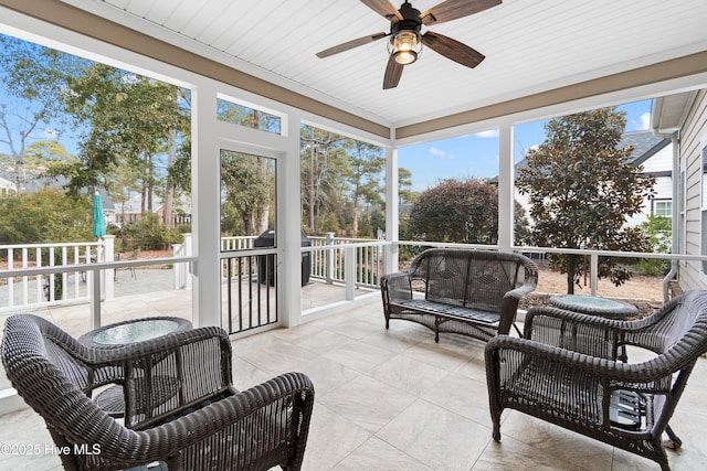 sunroom featuring ceiling fan