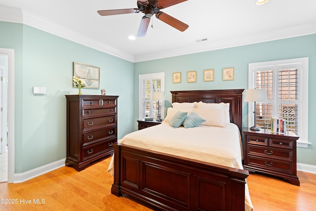 bedroom with crown molding, ceiling fan, multiple windows, and light wood-type flooring