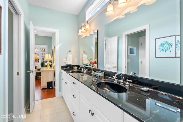 ensuite bathroom featuring double vanity, tile patterned floors, a sink, and ensuite bath