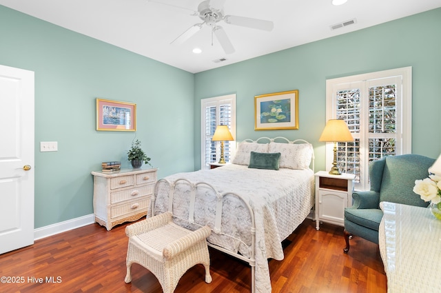 bedroom featuring dark wood-style flooring, visible vents, and multiple windows