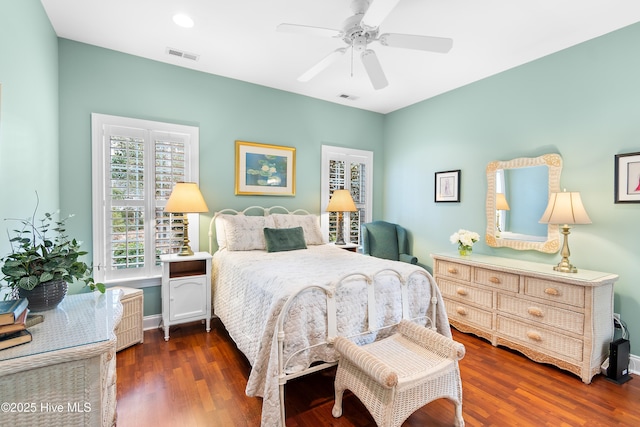 bedroom with dark wood-style flooring, a ceiling fan, and visible vents