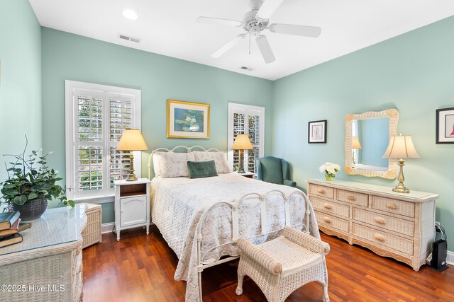 bedroom with multiple windows, dark wood-type flooring, and ceiling fan