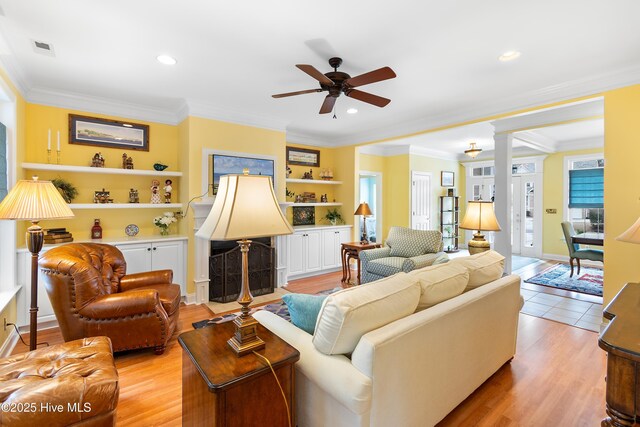 dining room featuring an inviting chandelier, ornamental molding, light hardwood / wood-style flooring, and ornate columns