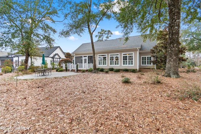 back of property featuring roof with shingles and a patio area