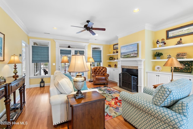 living room featuring crown molding, ceiling fan, and light hardwood / wood-style flooring