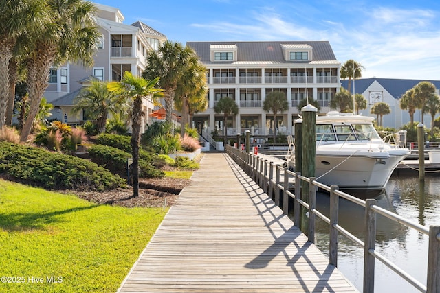 dock area with a water view and a yard