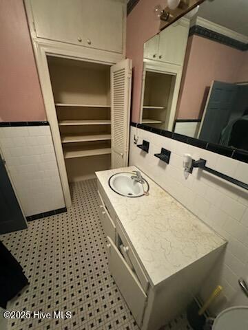 bathroom with vanity and tile walls