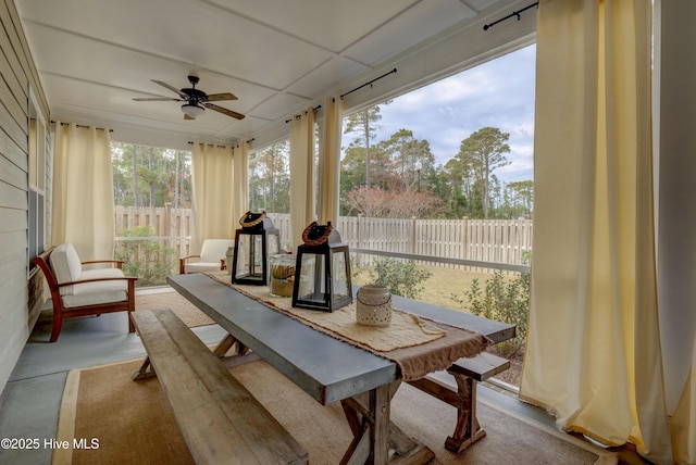 sunroom / solarium with a drop ceiling, ceiling fan, and a healthy amount of sunlight