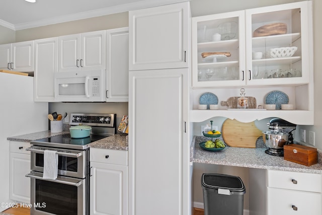 kitchen featuring double oven range, light stone countertops, white cabinetry, and ornamental molding