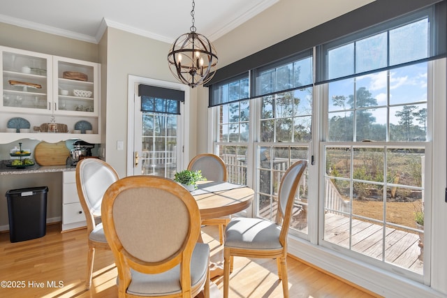 dining space featuring crown molding, a chandelier, and light hardwood / wood-style floors