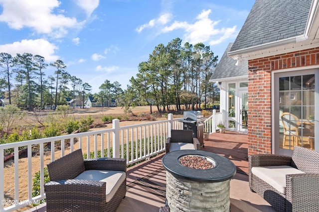 wooden deck with an outdoor fire pit and grilling area