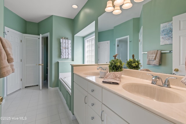 bathroom with tile patterned floors, vanity, and a tub to relax in