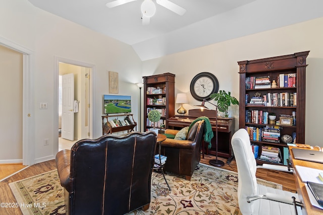 office space featuring ceiling fan, light wood-type flooring, and vaulted ceiling