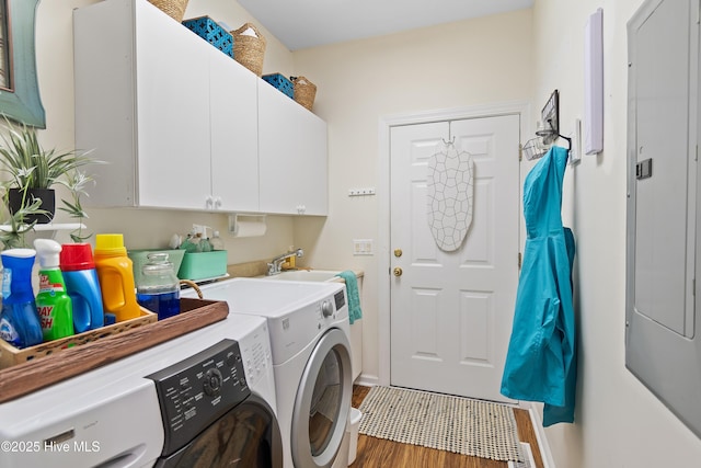 laundry room with cabinets, hardwood / wood-style floors, and washing machine and dryer