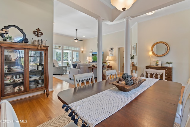 dining space with ceiling fan, light hardwood / wood-style flooring, ornamental molding, and ornate columns