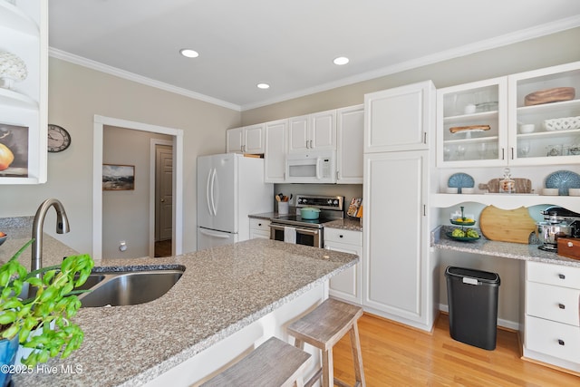 kitchen featuring light stone counters, sink, white appliances, and white cabinets