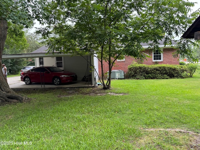 view of yard with a carport and central AC