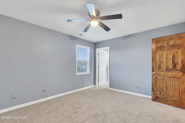 interior space featuring a textured ceiling, ceiling fan, and light colored carpet