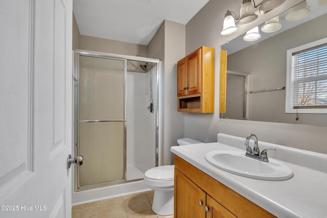 bathroom with tile patterned floors, a shower with door, toilet, and vanity