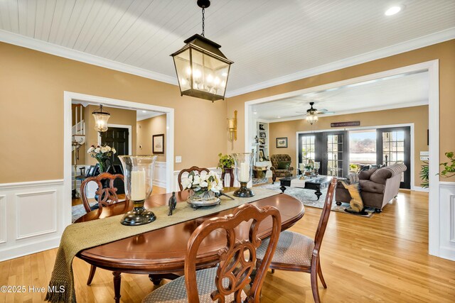 dining area featuring light hardwood / wood-style floors, crown molding, and ceiling fan with notable chandelier