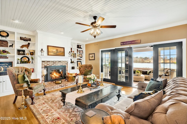 living room with light wood-type flooring, french doors, wooden ceiling, and a water view