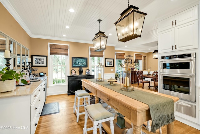 kitchen featuring decorative light fixtures, light hardwood / wood-style floors, wood ceiling, double oven, and white cabinets