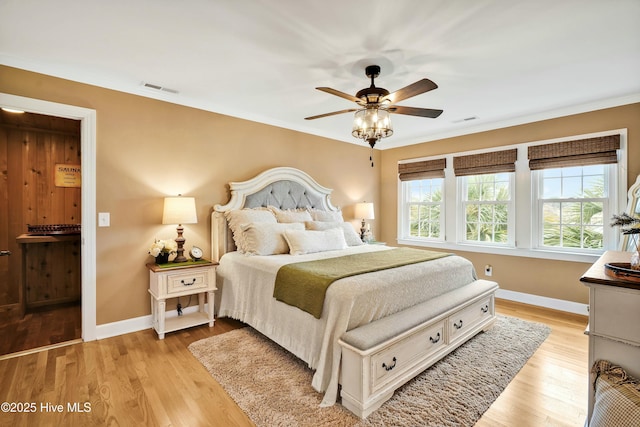 bedroom with ornamental molding, light wood-type flooring, ceiling fan, and multiple windows