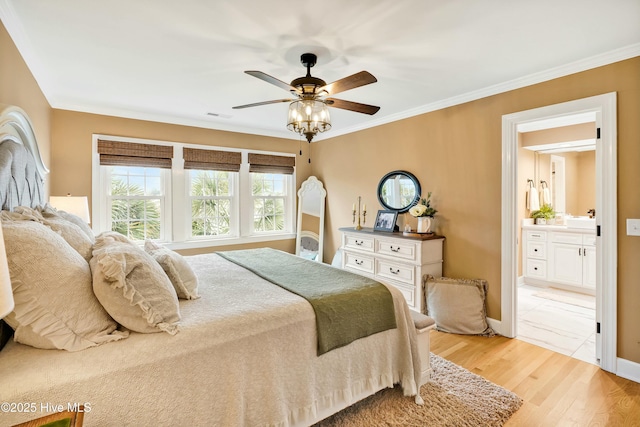 bedroom with ceiling fan, light wood-type flooring, ensuite bathroom, and ornamental molding