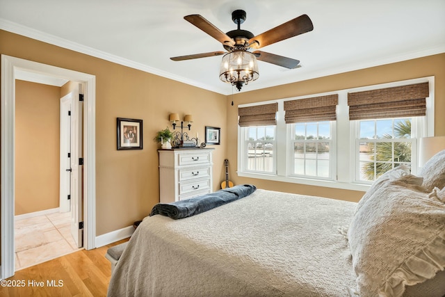 bedroom with ceiling fan, light hardwood / wood-style floors, crown molding, and multiple windows