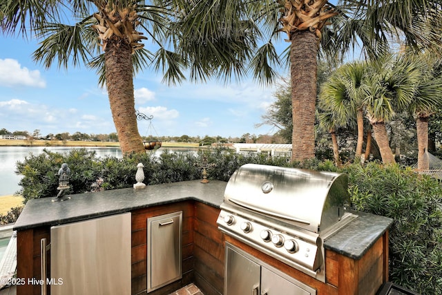 view of patio with a water view, area for grilling, and grilling area