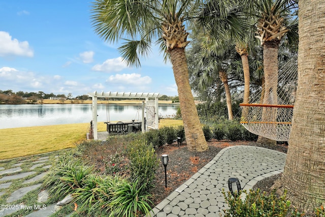 view of patio with a pergola and a water view