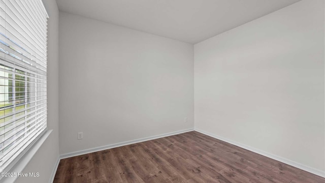 empty room with dark hardwood / wood-style flooring