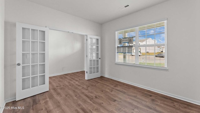 empty room with wood-type flooring and french doors