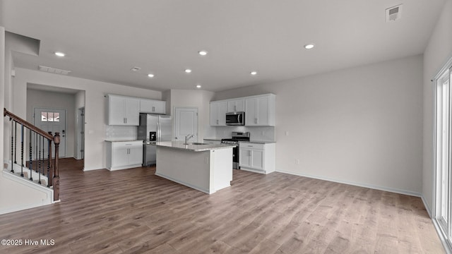 kitchen featuring sink, an island with sink, appliances with stainless steel finishes, tasteful backsplash, and white cabinetry