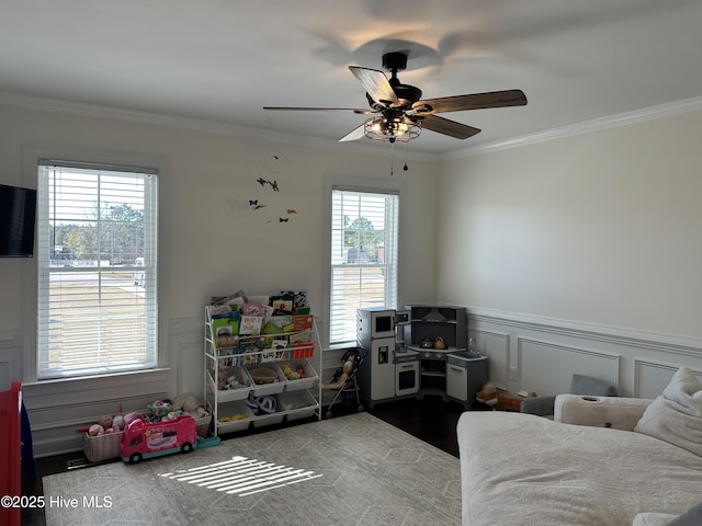 rec room with ceiling fan and ornamental molding