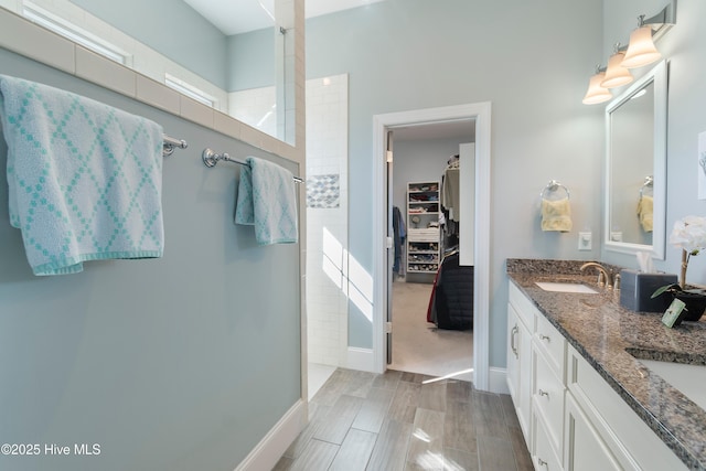 bathroom featuring a tile shower and vanity