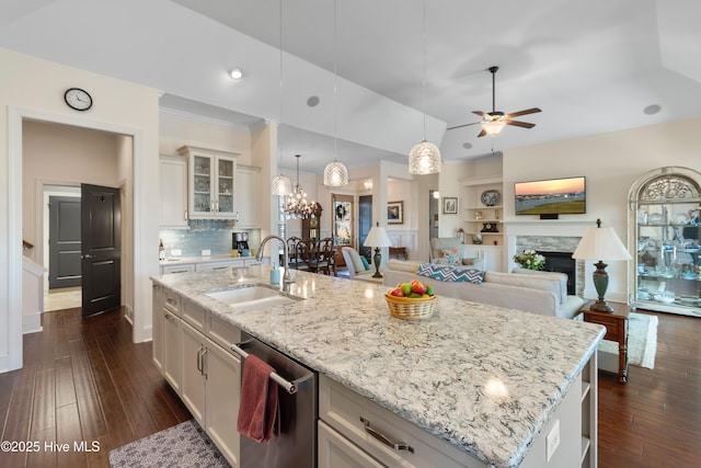 kitchen with sink, a center island with sink, dishwasher, pendant lighting, and white cabinets