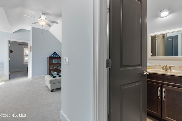 bathroom with ceiling fan, vanity, and vaulted ceiling