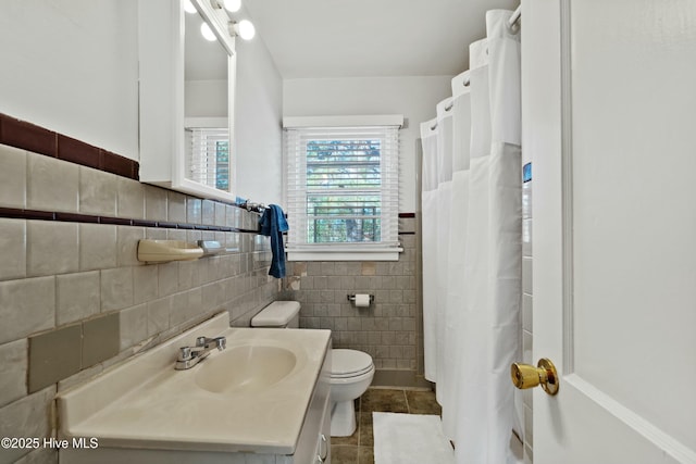 bathroom featuring toilet, tile walls, tile patterned floors, and vanity