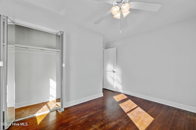 unfurnished bedroom featuring ceiling fan, dark hardwood / wood-style floors, and a closet