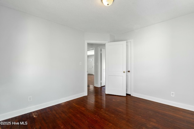 unfurnished room featuring dark wood-type flooring